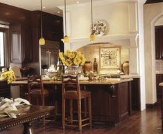 a large kitchen with wooden floors and brown cabinets, along with an island in the center