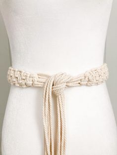 a white dress belt with braiding on the side and a knot at the waist