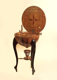 an old fashioned wooden sink with a cross on the front and side panel, sitting on top of a stand