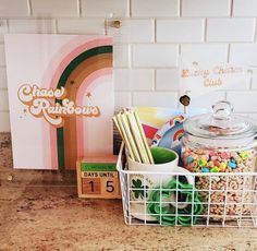 a basket filled with candy and other items next to a sign that reads happy rainbows