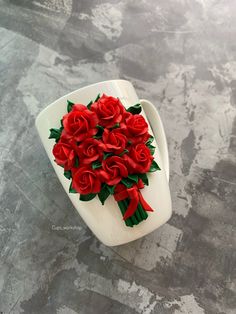 a bouquet of red roses in a white vase