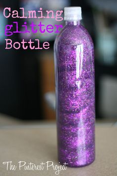 a purple glitter bottle sitting on top of a table