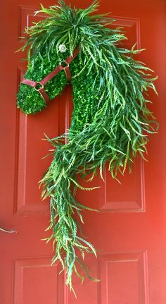 a horse head made out of plants on the front door to decorate it's entrance