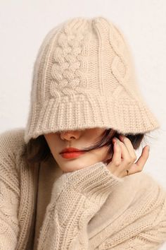 a woman wearing a beige hat and sweater