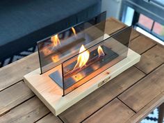 two glass fireplaces sitting on top of a wooden table