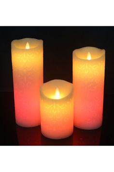 three lit candles sitting next to each other