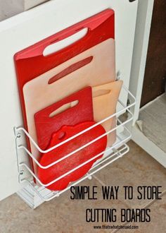 a white dish rack with red cutting boards in it