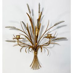 a metal wall sculpture with flowers and leaves on it's side, against a white background