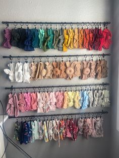 there is a rack with many different types of clothes hanging from it's hooks