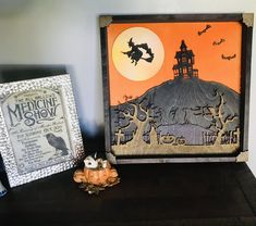 two halloween decorations are sitting on a shelf next to an old fashioned photo frame and pumpkins