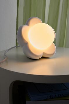 a white flower shaped lamp sitting on top of a table