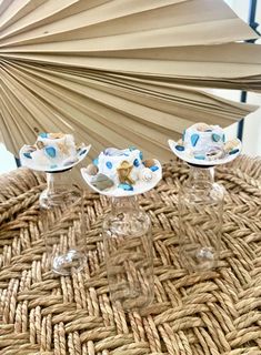 three wine glasses sitting on top of a wicker table