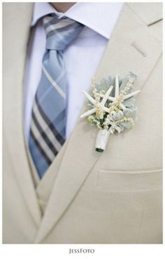 a man in a suit and tie with a boutonniere on his lapel