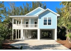 a blue and white house surrounded by trees