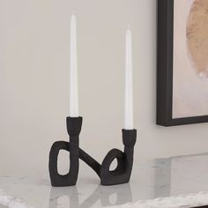 two candles sitting on top of a marble table