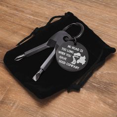 a pair of scissors sitting on top of a black bag next to a keychain