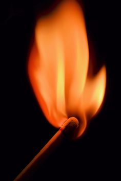 a matchstick is lit up in the dark with bright orange flames coming out of it