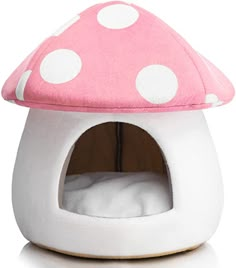 a pink mushroom shaped bed with white polka dots on the top and bottom, in front of a white background