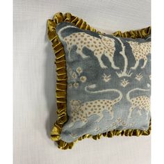 a blue and white pillow with gold ruffled edges