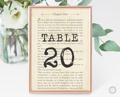 a table number sign with flowers in a vase