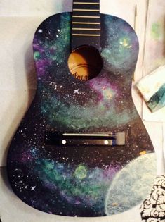 an image of a guitar with space painted on it