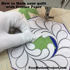 a person using a machine to make a quilt with freezer paper on the table