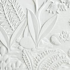 an intricately designed wallpaper with white flowers and leaves on it's surface