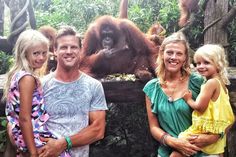 three adults and two children standing in front of an oranguel