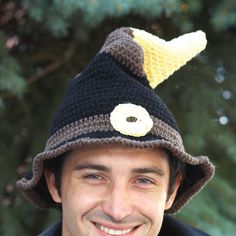 a man wearing a crocheted hat with a doughnut on top of it