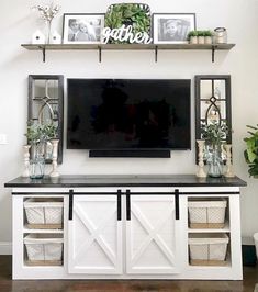 a flat screen tv mounted to the side of a wall above a white entertainment center