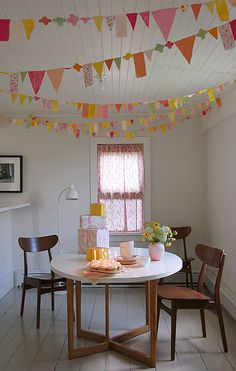 a white table with two chairs and a cake on it