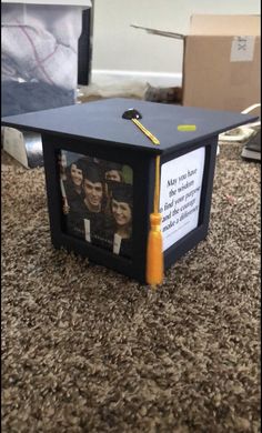 a graduation cap that has been placed on top of a box with pictures inside it