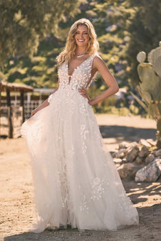 a woman in a wedding dress posing for the camera with her hands on her hips