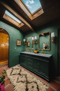 a bathroom with green walls and two sinks under a skylight in the middle of it