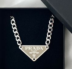 This Beige & Silver Triangular Logo Choker has been reworked from an authentic Prada bag tag. Very limited stock available! Silver Prada Necklace, Prada Necklace, Christian Dior Bracelet, Dior Necklace, Prada Jewelry, Rhinestone Letters, Chanel Necklace, Gold Letter Necklace, Silver Gold Jewelry