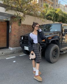 a woman standing in front of a black truck