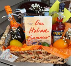 a basket filled with oranges, lemons and bottles of alcohol next to a sign that says one italian summer