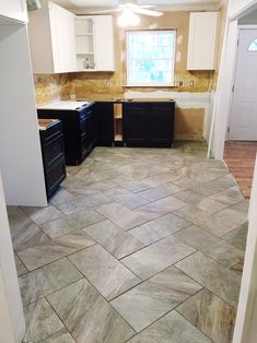 an empty kitchen with black appliances and white cabinets