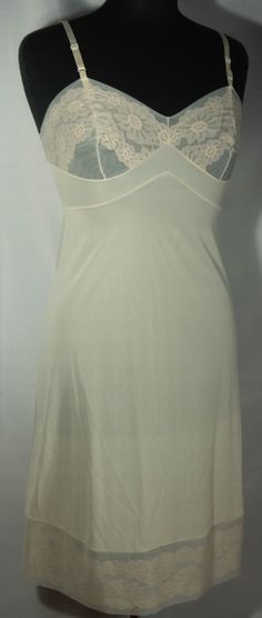 "Here's a late 60s/early 70s made in U.S.A. off white cream color slip dress that is in great condition with the iconic Vanity Fair label. This slip has adjustable shoulder straps, fitted bodice top and skirt slip to the knee lower half that's trimmed in lace. Perfect! The original Vanity Fair label says it's a size 32 and laid-flat measurements are included here for you to check the fit - it seems tiny! This is a lovely slip is a basic that's so versatile and makes a great vintage wardrobe stap Slip Dress Undergarment, 70s Slip Dress, Vintage Slip Skirt, Fitted Cream Camisole With Built-in Bra, White Sheer Slip Dress For Summer, White Fitted Slip Dress For Loungewear, White Sheer V-neck Slip Dress, Beige Slip Dress For Summer Sleep, Beige Summer Slip Dress For Sleep