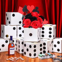 a bunch of dice boxes with roses in them and some cards on the table next to it