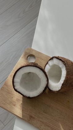 two pieces of coconut sitting on top of a wooden cutting board