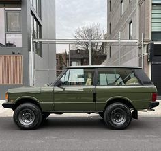 an suv is parked on the street in front of some buildings