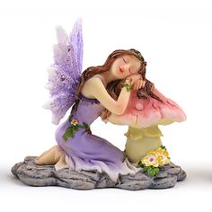 a figurine of a fairy sitting on a mushroom