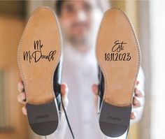 a pair of shoes with the words hubby and east printed on them are held in front of a man's face