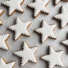 several decorated cookies are arranged in rows on a sheet of parchment paper with white icing