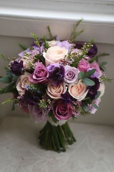 a bouquet of flowers sitting on top of a window sill