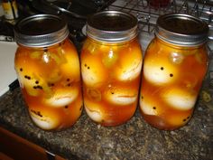 three jars filled with liquid sitting on top of a counter