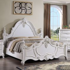 a white bed sitting in a bedroom next to a dresser and mirror on top of a hard wood floor