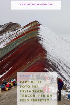 people are standing on the side of a mountain covered in red, green and blue paint