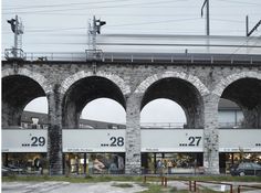 an old brick building with arched arches and people walking around the entrance to the store